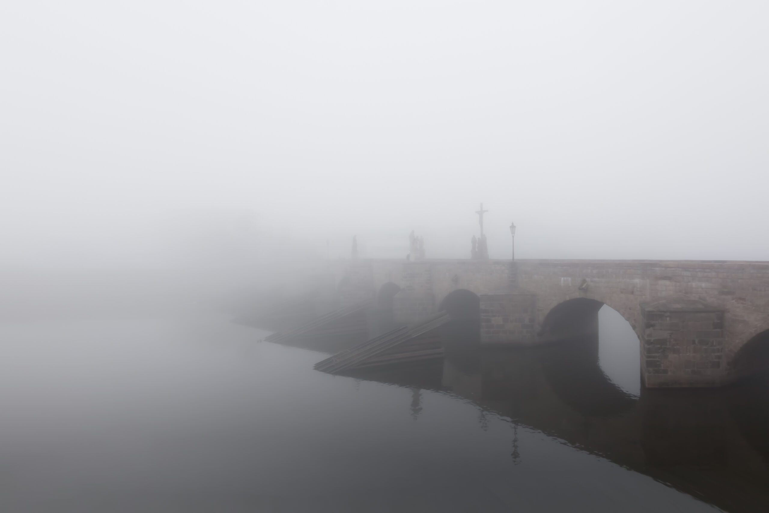 This atmospheric print captures the ethereal beauty of Pisek’s ancient stone bridge, vanishing poetically into a dense fog, creating a surreal and enchanting visual narrative.
