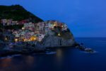 This striking image This image encapsulates a serene twilight moment in Manarola, where the first hints of evening lights begin to sprinkle the town, creating a magical ambiance. a solitary figure amidst the historic beauty of Cadiz, offering a tale of reflection and timelessness.