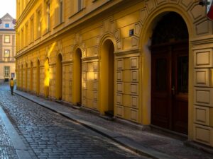 A vivid depiction of Prague at dawn, capturing the golden light that graces the facade of a classic Czech building.