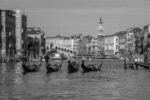 Experience the poetry of Venice through this exquisite black and white representation, showcasing a quartet of gondolas gracefully navigating the Grand Canal.