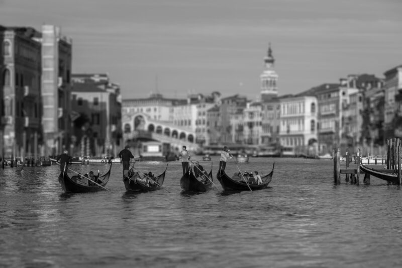 Experience the poetry of Venice through this exquisite black and white representation, showcasing a quartet of gondolas gracefully navigating the Grand Canal.