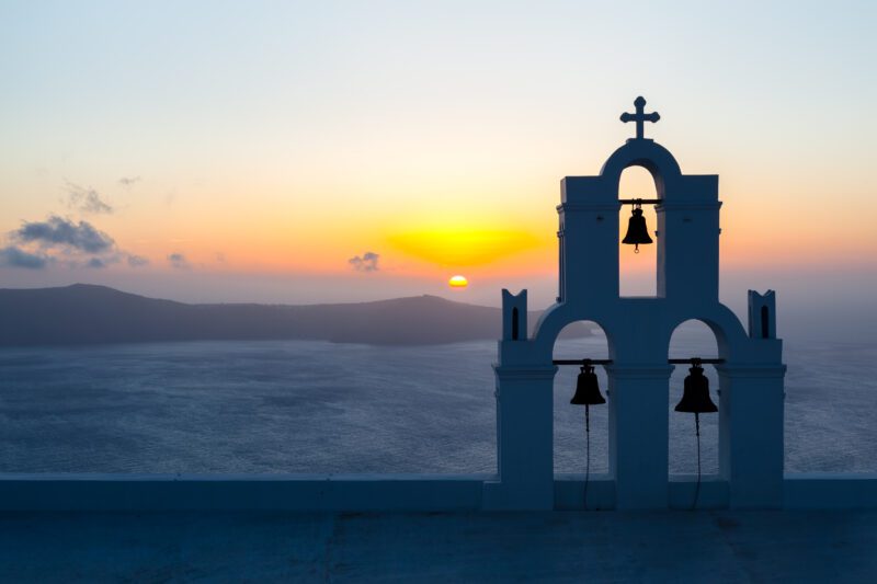 Sunset behind The Three Bells of Fira, Santorini.