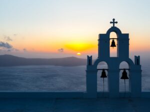 Sunset behind The Three Bells of Fira, Santorini.