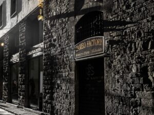 Sunlit street in Florence with historic stone buildings.