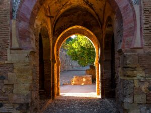 Image of an archway in the ancient Alhambra complex, showcasing detailed architectural designs.