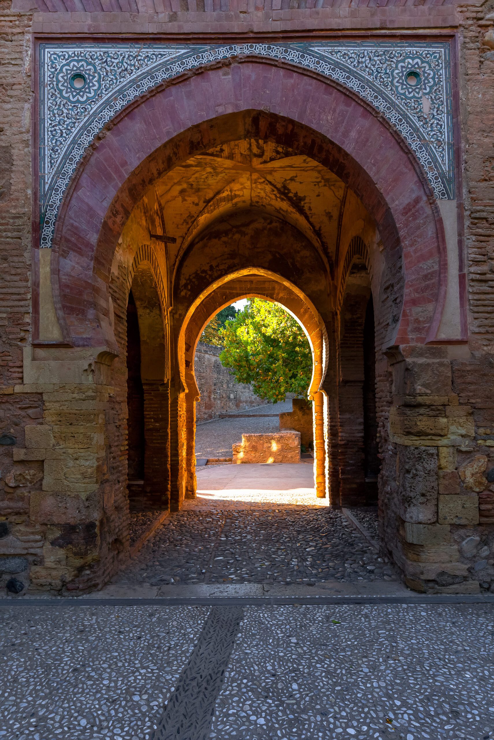 Image of an archway in the ancient Alhambra complex, showcasing detailed architectural designs.