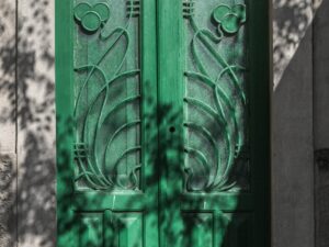 Emerald green door in Chora, Mykonos with intricate patterns.