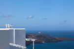 Two white chairs overlooking the Aegean Sea in Fira, Santorini