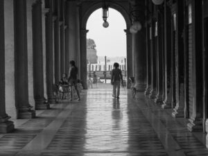 Black and white photograph of St. Marks Plaza, Venice with person walking.