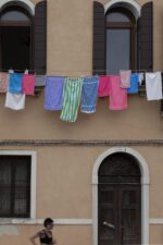 Venetian building with hanging laundry and a passerby