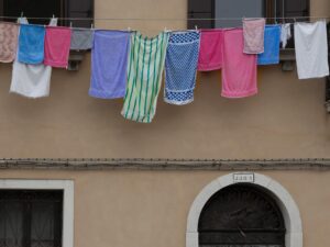 Venetian building with hanging laundry and a passerby