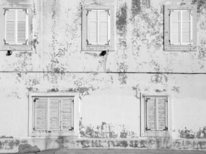 Aged building facade in Zadar with rustic shutters