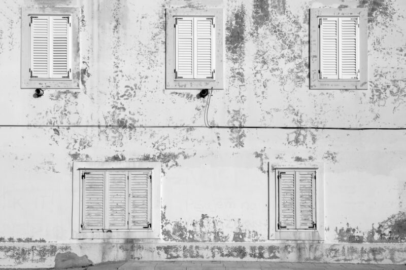 Aged building facade in Zadar with rustic shutters