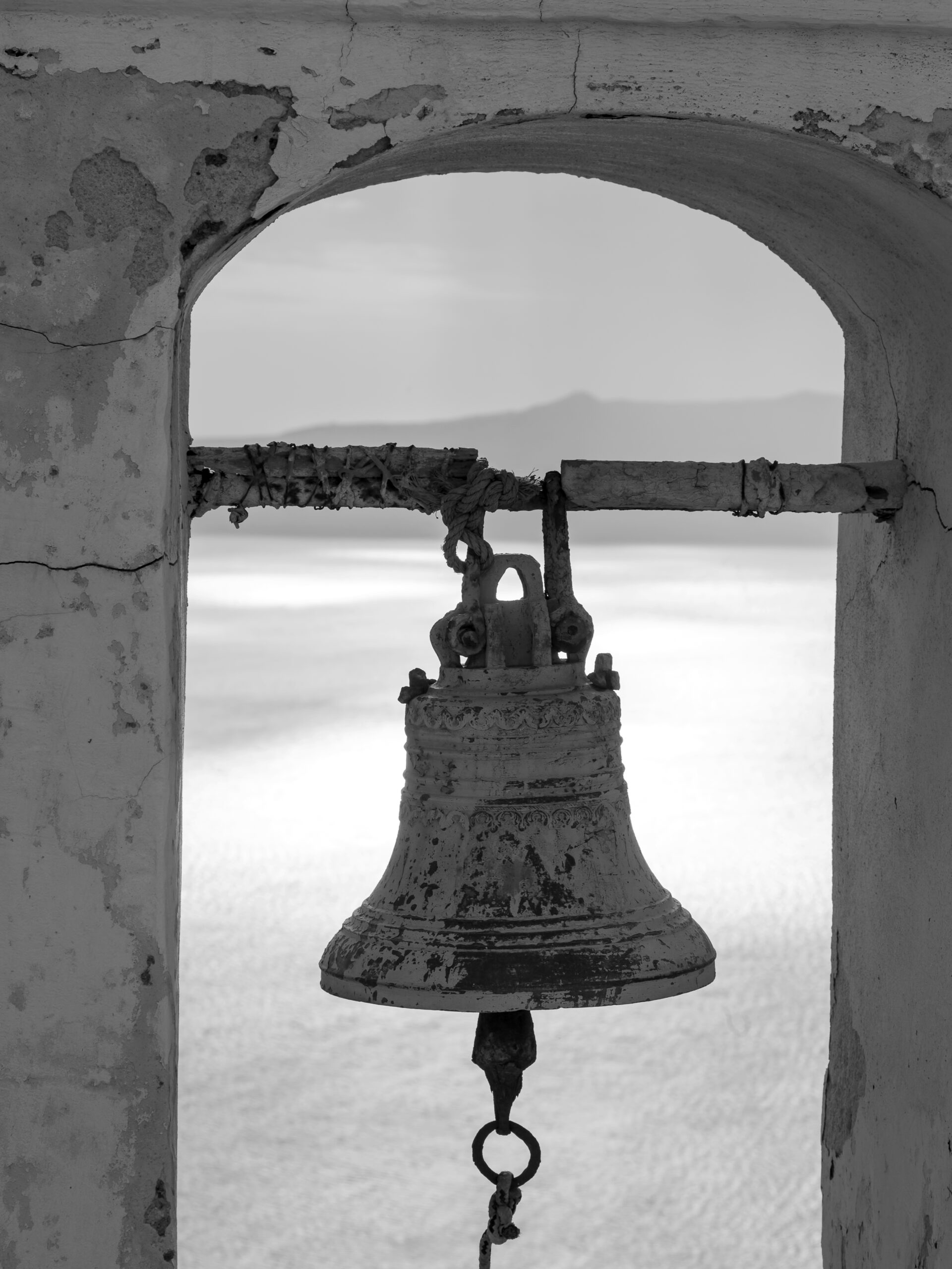 Ancient bell in black and white, overlooking the caldera in Santorini, Greece.