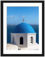 Blue domed church in Santorini overlooking the serene blue waters of the caldera