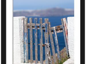 Weathered blue wooden fence with ocean view in Santorini, Greece.