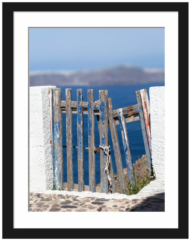 Weathered blue wooden fence with ocean view in Santorini, Greece.