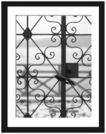 Black and white photo of an old iron gate in Fira, Santorini overlooking the sea.