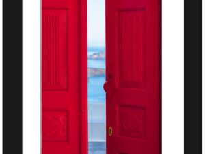Bright red doorway opening to a view of the Santorini caldera with blue waters below.