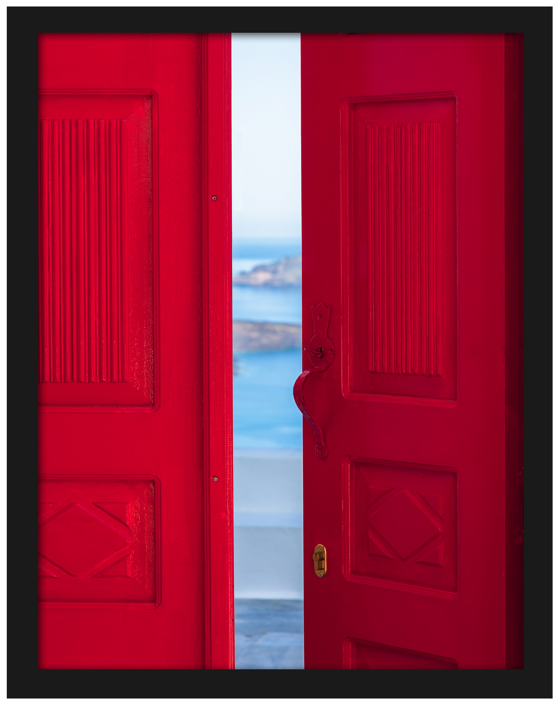 Bright red doorway opening to a view of the Santorini caldera with blue waters below.