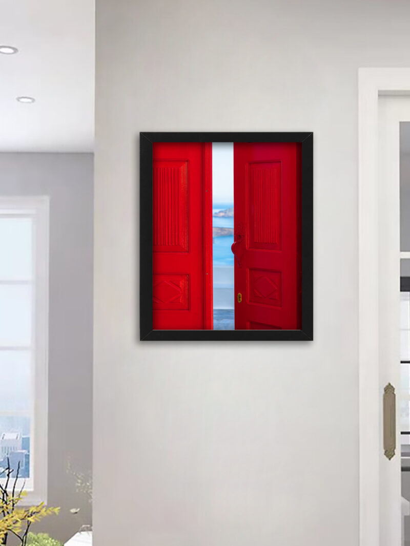 Bright red doorway opening to a view of the Santorini caldera with blue waters below.