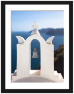 White bell tower with an angel sculpture on top, overlooking the deep blue sea in Santorini, Greece.