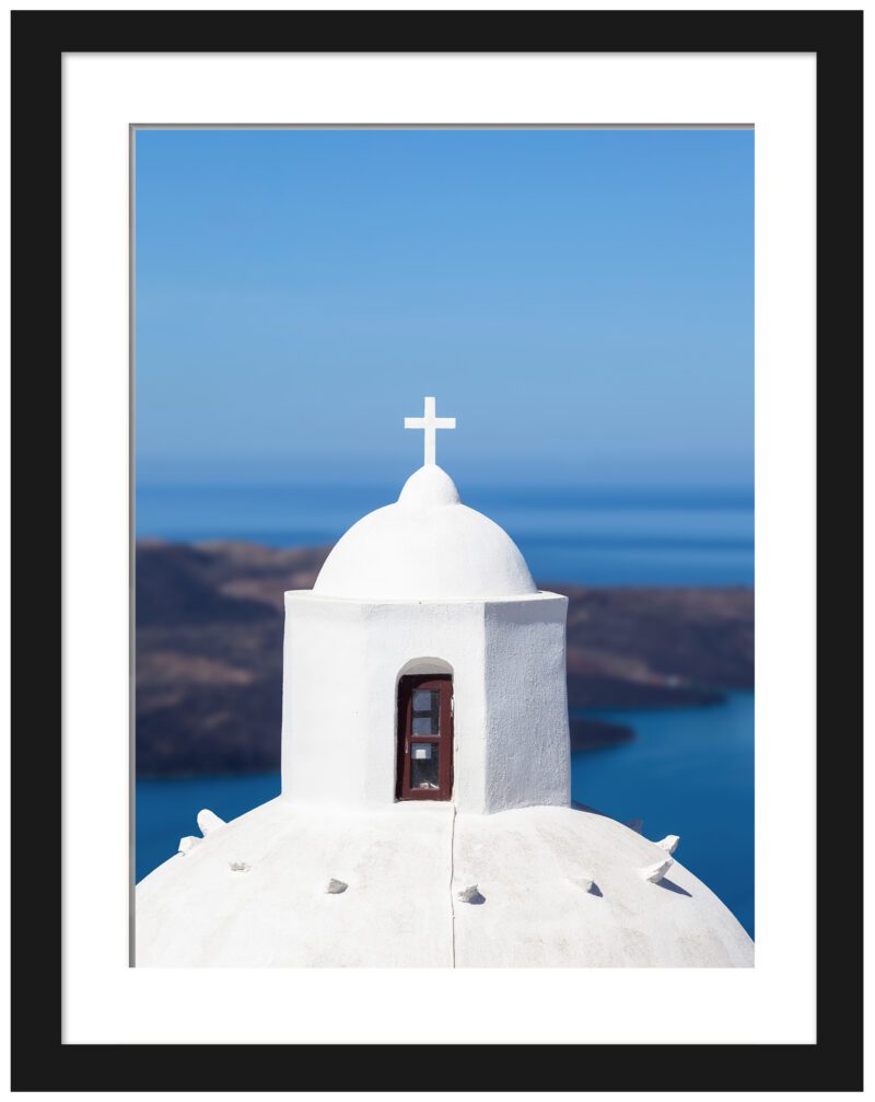White-domed church in Santorini with a clear view of the blue caldera.