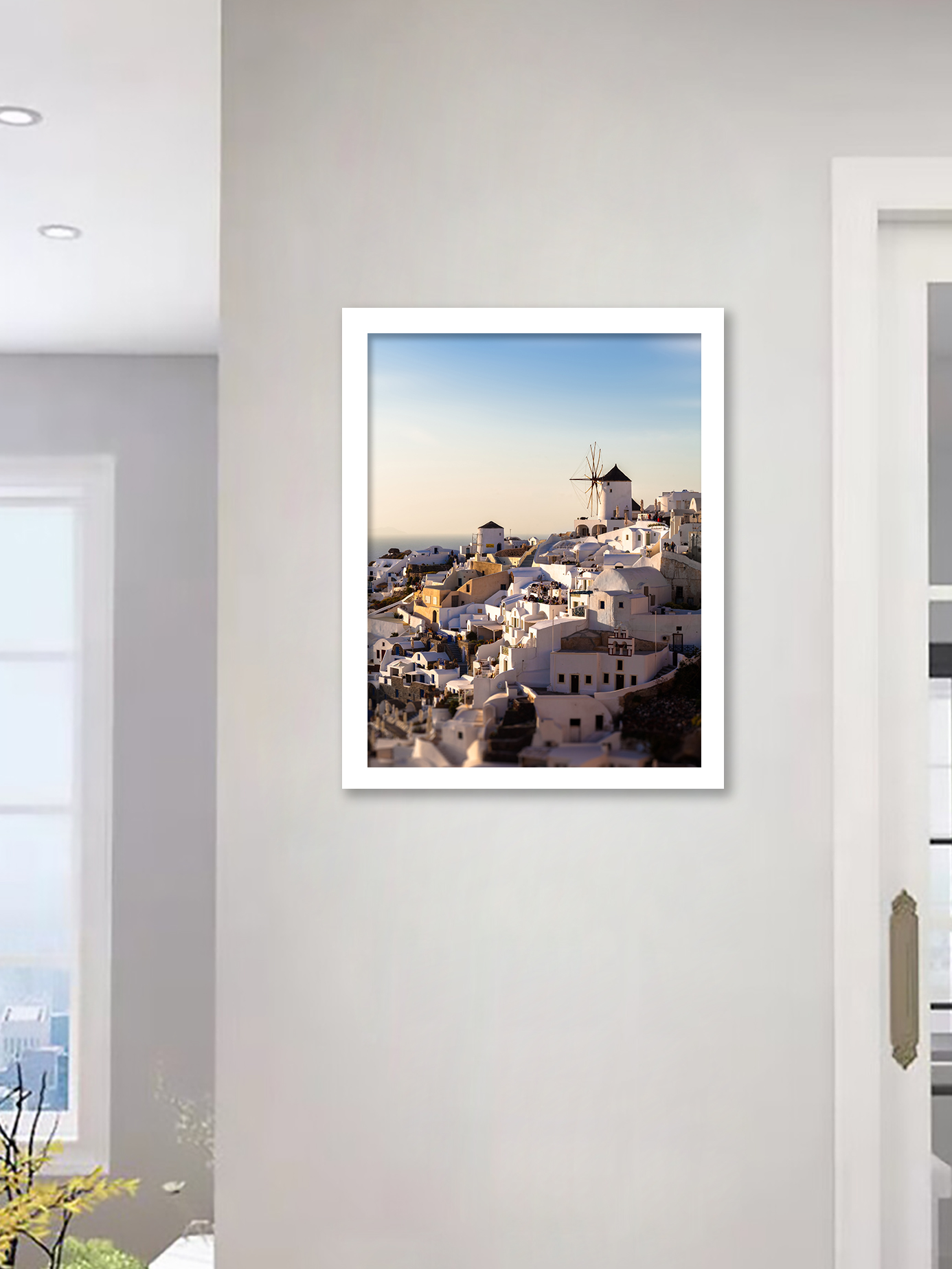 The village of Oia in Santorini, Greece, captured at dusk with soft golden lighting illuminating the iconic windmills and white buildings.