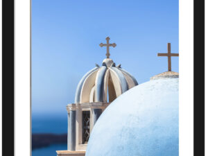Iconic blue church domes under the clear sky in Santorini, Greece.