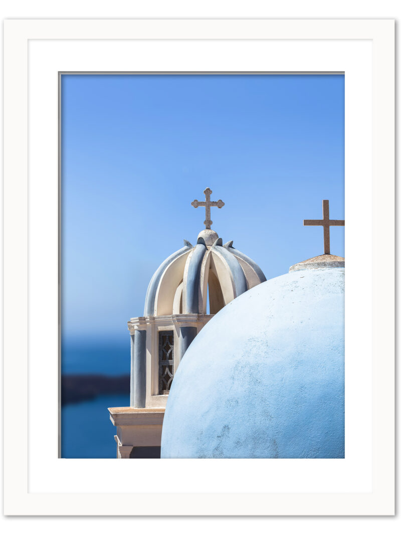 Iconic blue church domes under the clear sky in Santorini, Greece.