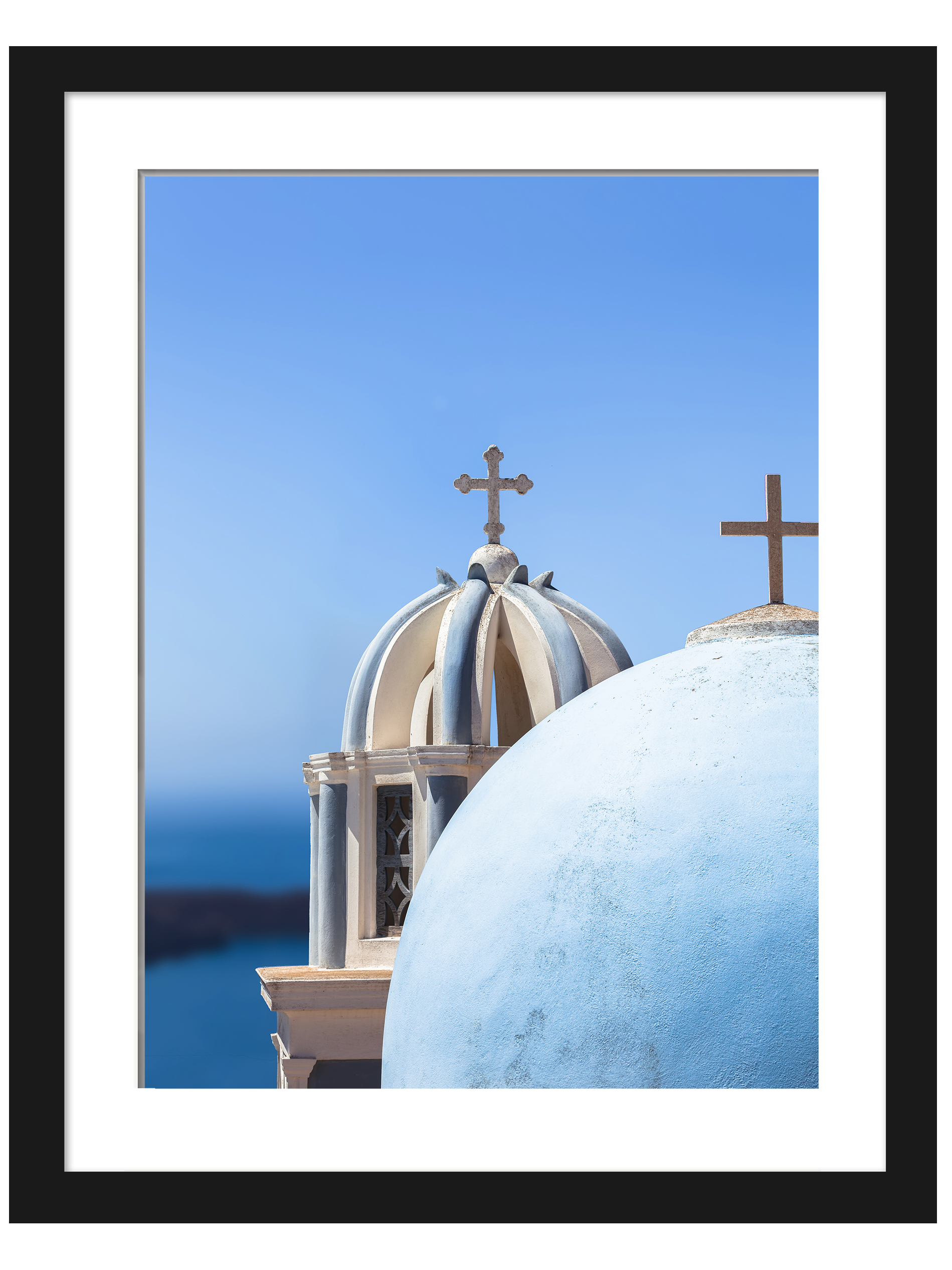 Iconic blue church domes under the clear sky in Santorini, Greece.