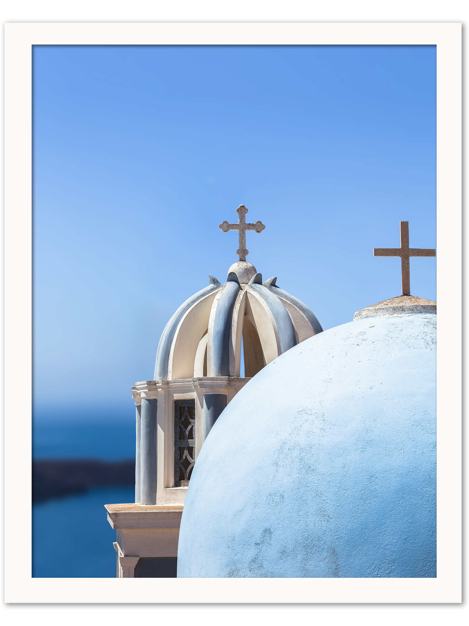 Iconic blue church domes under the clear sky in Santorini, Greece.