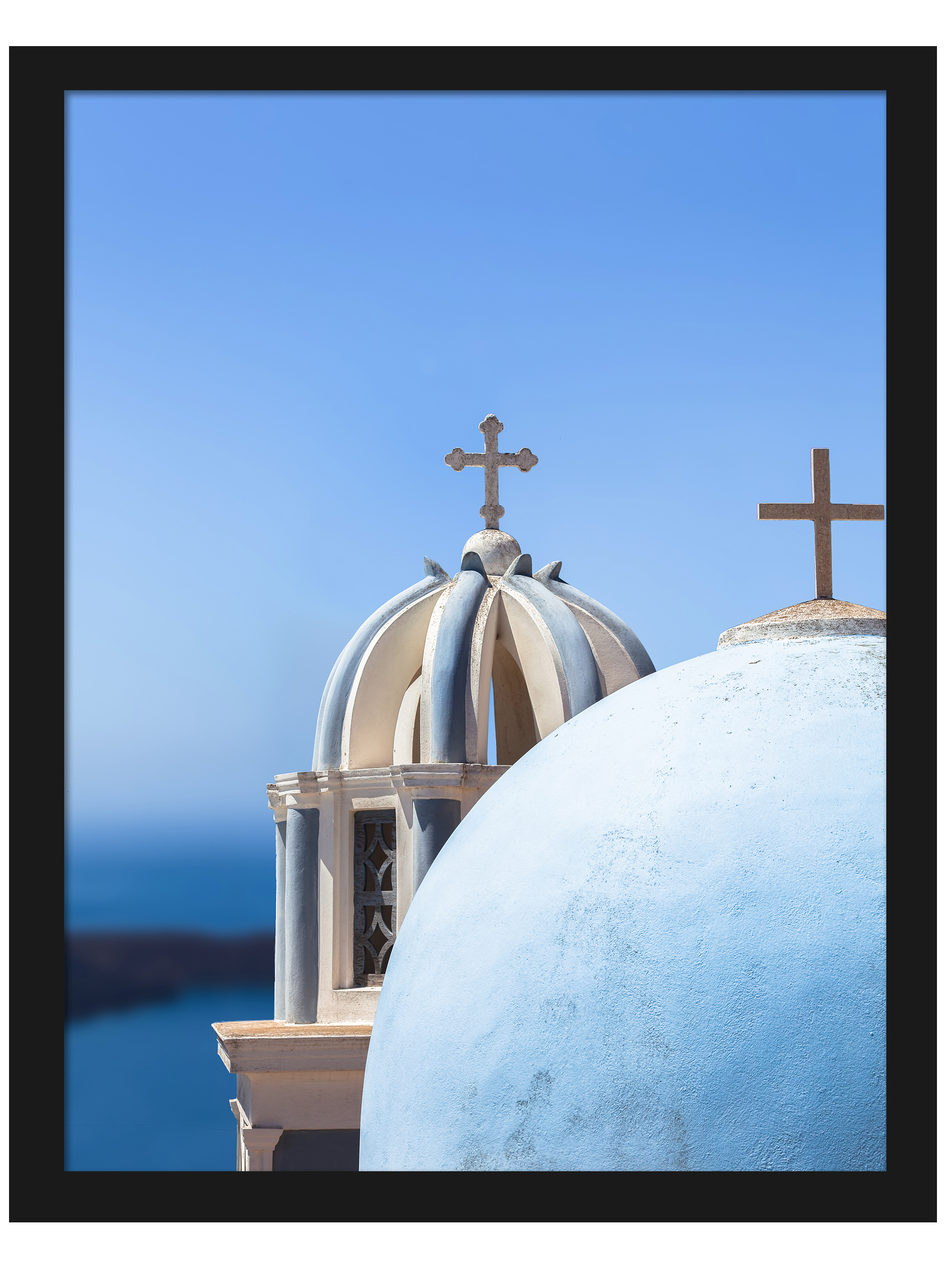 Iconic blue church domes under the clear sky in Santorini, Greece.