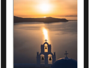 Church bells silhouette against a golden sunset in Santorini, Greece.