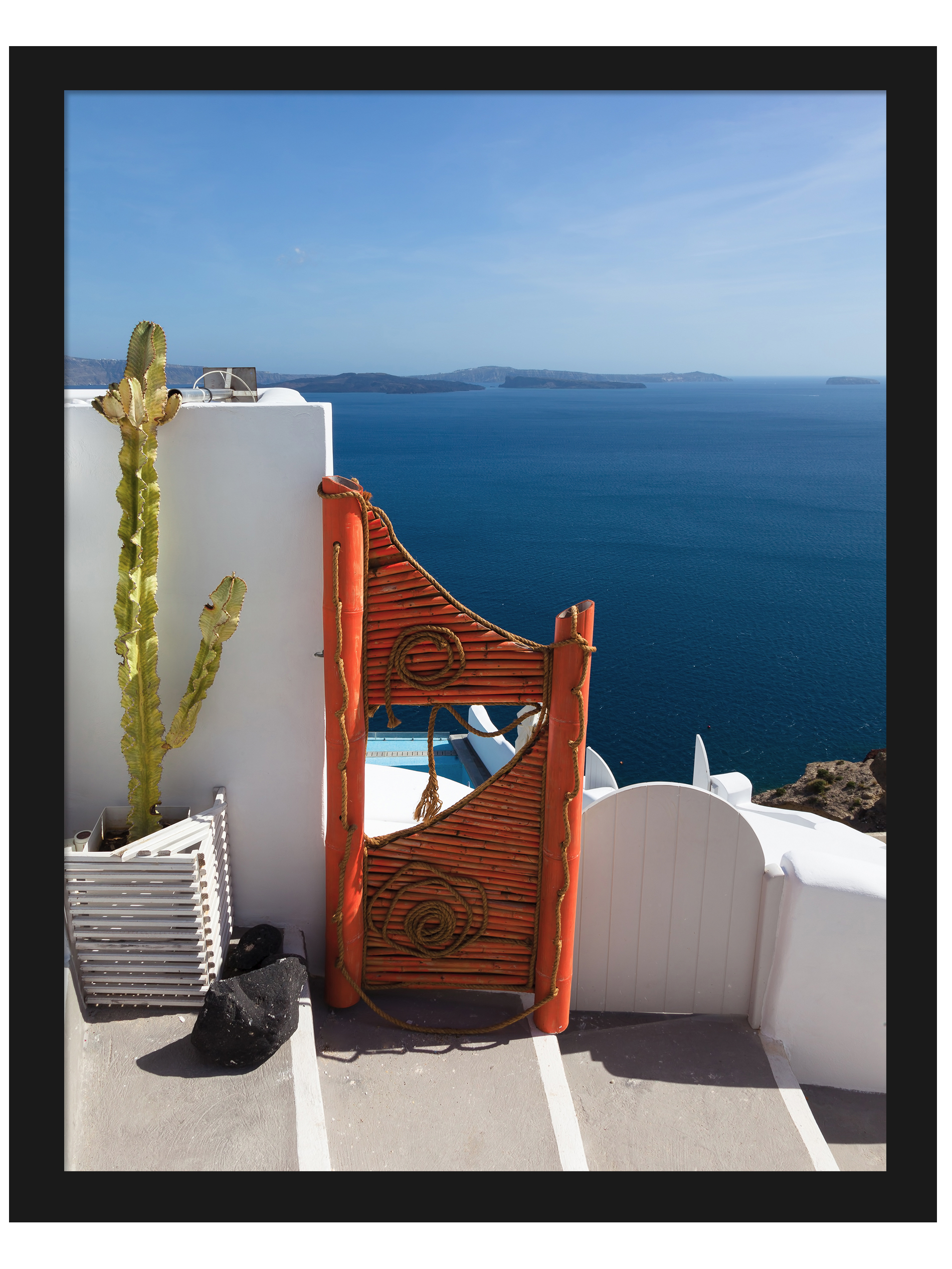 Vibrant orange gate in Fira, Santorini overlooking the clear blue caldera waters.