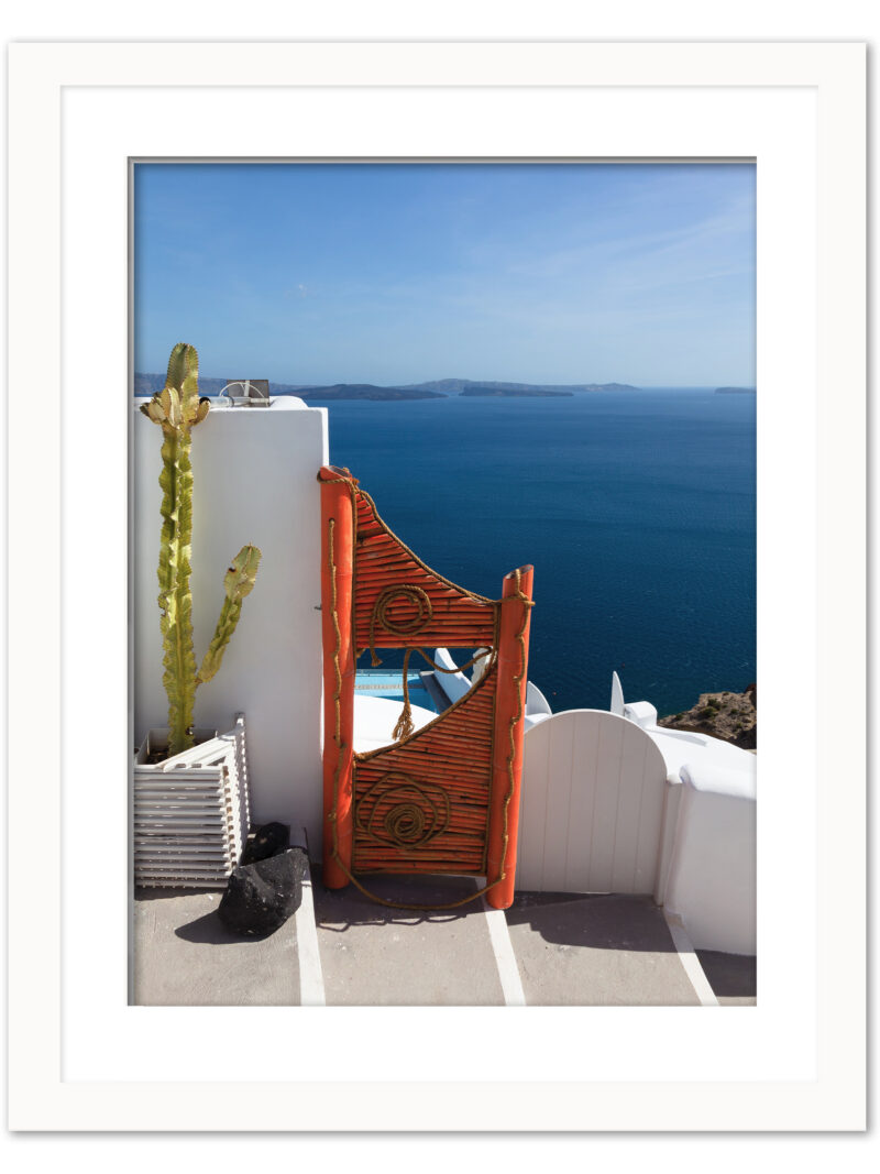 Vibrant orange gate in Fira, Santorini overlooking the clear blue caldera waters.