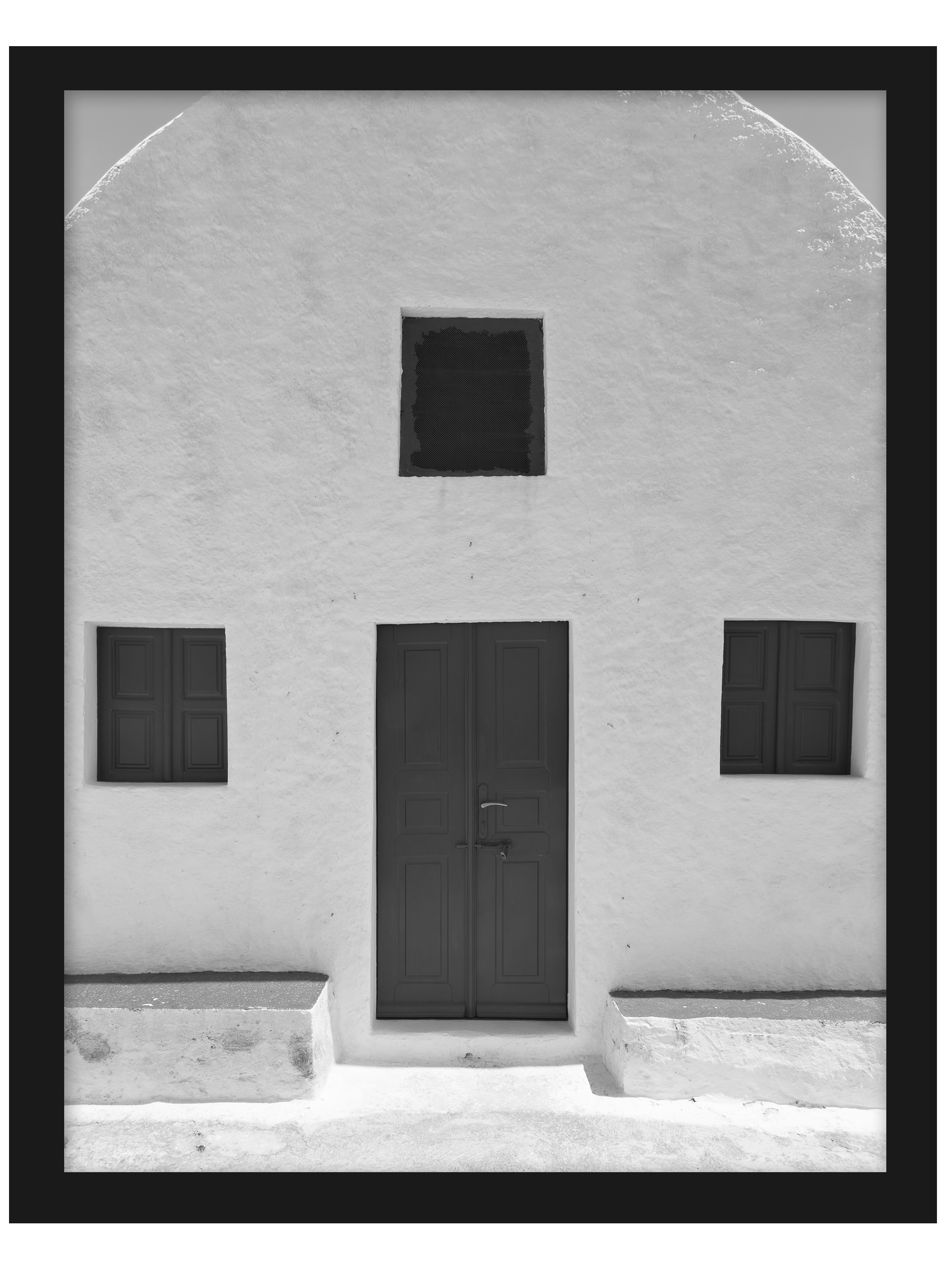 Simple white house in Santorini with symmetric windows and a minimalist design.