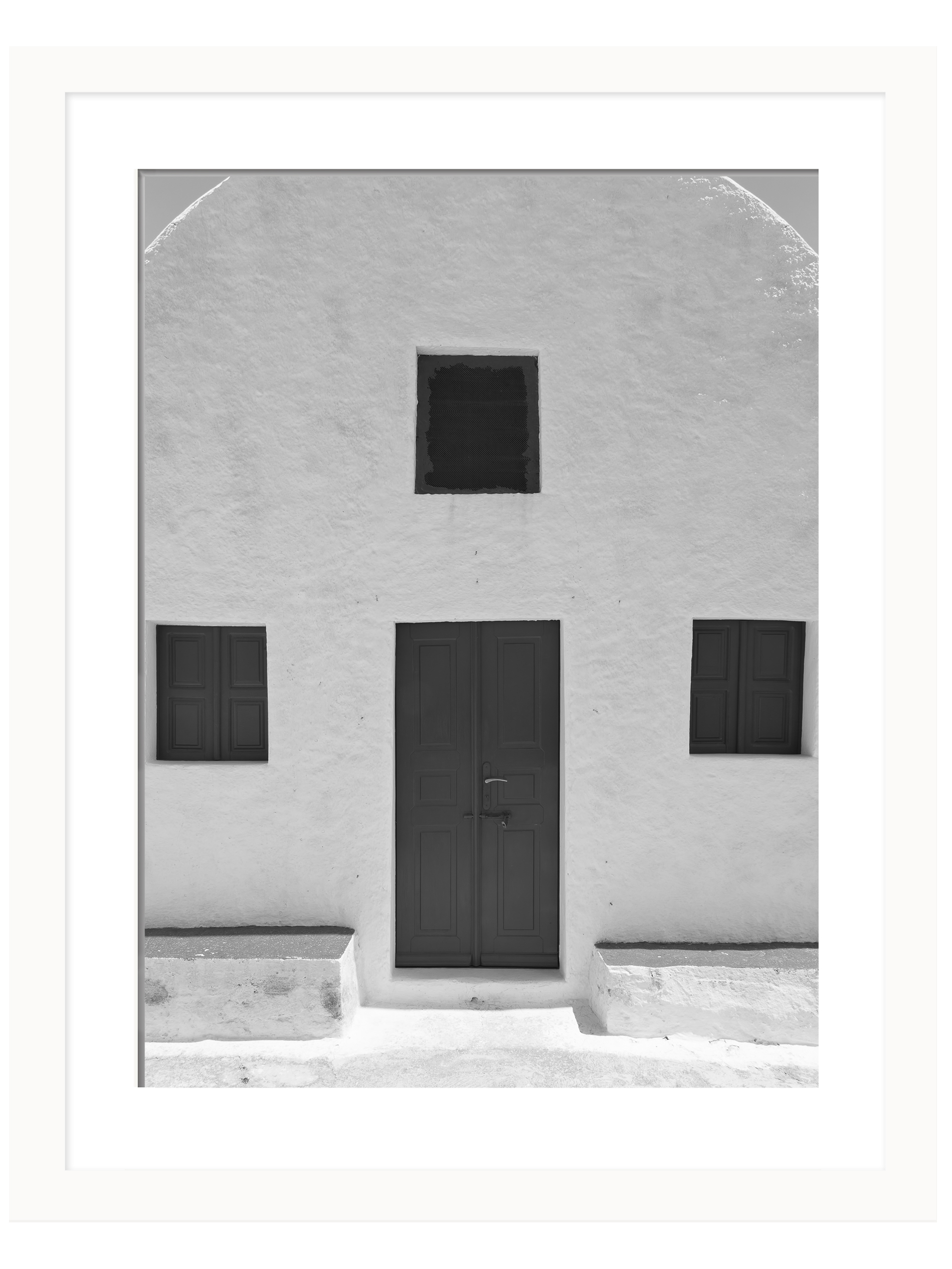 Simple white house in Santorini with symmetric windows and a minimalist design.