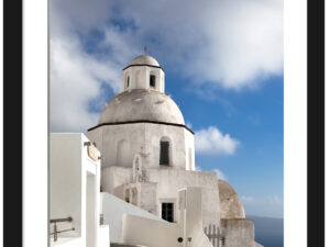 A scenic walkway in Fira, Santorini leading to a white domed church under a bright blue sky.